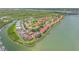 Aerial view of waterfront condos with red tile roofs, lush landscaping, and a winding waterway at 445 Bouchelle Dr # 104, New Smyrna Beach, FL 32169