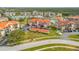Aerial view of condo complex with pool, lush landscaping, and parking area surrounded by trees at 445 Bouchelle Dr # 104, New Smyrna Beach, FL 32169