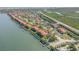 Scenic aerial view of waterfront condos with red tile roofs, marina, and lush green landscaping at 445 Bouchelle Dr # 104, New Smyrna Beach, FL 32169