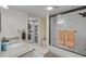 Bathroom featuring granite vanity and tiled shower with glass doors, plus stacked laundry in closet at 445 Bouchelle Dr # 104, New Smyrna Beach, FL 32169