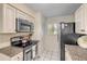 Kitchen featuring white cabinets, granite countertops and black stove at 445 Bouchelle Dr # 104, New Smyrna Beach, FL 32169