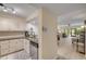 Well-lit kitchen featuring white cabinets, granite countertops and view to living area at 445 Bouchelle Dr # 104, New Smyrna Beach, FL 32169