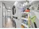 Efficient laundry room with stacked washer and dryer and shelving for ample storage space at 445 Bouchelle Dr # 104, New Smyrna Beach, FL 32169