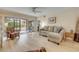 Relaxing living room featuring a ceiling fan and sliding glass doors leading to the screened lanai at 445 Bouchelle Dr # 104, New Smyrna Beach, FL 32169