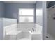 Bright bathroom with large soaking tub under window, separate shower, and light blue walls at 4618 Prairie Point, Kissimmee, FL 34746
