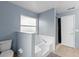 Bathroom featuring a soaking tub, shower, and toilet with tiled floors and light blue walls at 4618 Prairie Point, Kissimmee, FL 34746