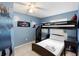 A room with blue walls and a bunkbed with black frame and an accompanying desk at 4618 Prairie Point, Kissimmee, FL 34746