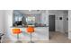 Open-concept kitchen featuring a breakfast bar with modern orange bar stools at 4618 Prairie Point, Kissimmee, FL 34746