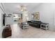 Open living room with tile flooring, a black leather sofa, and sliding glass doors leading to a pool at 4618 Prairie Point, Kissimmee, FL 34746