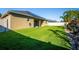 Large grassy backyard with solar panels on roof, complemented by lush landscaping, privacy fence, and patio at 4862 Grand Vista Ln, St Cloud, FL 34771