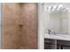 Close-up of the bathroom with tiled shower, granite countertop, dark vanity, and modern lighting at 4862 Grand Vista Ln, St Cloud, FL 34771