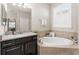 Here's a close-up of a bathroom with granite counters, dark cabinets, and separate tub beneath a window with shutters at 4862 Grand Vista Ln, St Cloud, FL 34771