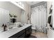 Bathroom view with double sinks, quartz countertops, a large mirror, and a floral patterned shower curtain at 4862 Grand Vista Ln, St Cloud, FL 34771