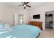 This bedroom features a ceiling fan and a door leading to the backyard, plus a television, dresser, and closet at 4862 Grand Vista Ln, St Cloud, FL 34771