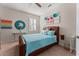 This is a bedroom featuring a ceiling fan and a window with shutters for natural light, plus colorful wall decor at 4862 Grand Vista Ln, St Cloud, FL 34771