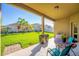 Covered patio with table and chairs overlooking the lush backyard and tropical landscaping at 4862 Grand Vista Ln, St Cloud, FL 34771
