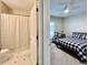 Comfortable bedroom featuring plush carpet, ceiling fan, and natural light with an adjacent bathroom at 489 Water St # 489, Celebration, FL 34747