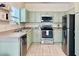 Well-lit kitchen with stainless steel appliances and light green cabinets at 489 Water St # 489, Celebration, FL 34747