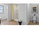 Modern bathroom with a large shower and neutral tilework, adjoined to walk-in closet and toilet with wall art at 5215 Ligonberry St, Lakeland, FL 33811