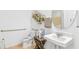 Bright bathroom features a pedestal sink, decorative shelves, and accessibility bar at 5215 Ligonberry St, Lakeland, FL 33811