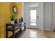 Bright entryway with yellow accent wall and decorative console table with mirror and modern decor at 5215 Ligonberry St, Lakeland, FL 33811