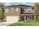 Two-story home featuring a two-car garage, neutral colored stucco exterior, and lush landscaping at 5215 Ligonberry St, Lakeland, FL 33811
