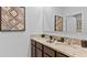 Elegant bathroom with double sinks, granite countertops, dark wood cabinets, and modern fixtures at 5219 Ligonberry St, Lakeland, FL 33811