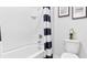 Clean bathroom featuring a white tub-shower combination, a toilet, and contemporary decor at 5219 Ligonberry St, Lakeland, FL 33811