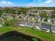 Aerial view of a residential area featuring lush greenery, tranquil pond, and distant city skyline at 5669 Parkview Lake Dr, Orlando, FL 32821