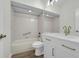 Bright bathroom features a bathtub and shower combination, alongside a white vanity with brushed gold hardware at 5669 Parkview Lake Dr, Orlando, FL 32821