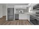 Modern kitchen featuring stainless steel appliances, white cabinetry, and wood-look flooring at 5669 Parkview Lake Dr, Orlando, FL 32821