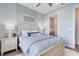 Calming bedroom with light blue walls, neutral bedding, and ensuite bathroom access at 6006 Forest Perch Dr, St Cloud, FL 34771