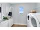 Clean laundry room with modern washer and dryer, storage cabinets, folding rack, and ample natural light at 6006 Forest Perch Dr, St Cloud, FL 34771