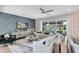 Bright living room features a modern gray accent wall, neutral furniture, and sliding glass doors to the backyard at 6006 Forest Perch Dr, St Cloud, FL 34771