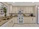 Well-lit kitchen boasts granite countertops, white cabinetry, and stainless-steel appliances at 638 Maple Oak Cir # 112, Altamonte Springs, FL 32701