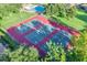 Aerial view of the community tennis courts surrounded by trees and green grass at 638 Maple Oak Cir # 112, Altamonte Springs, FL 32701