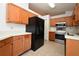 Traditional kitchen features wood cabinets, black refrigerator, and neutral countertops at 691 Monroe Harbor Pl, Sanford, FL 32773