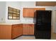 View of the kitchen with wood cabinets, white countertops, and black refrigerator at 691 Monroe Harbor Pl, Sanford, FL 32773