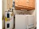 Laundry room featuring a water heater, washer, dryer, and wooden cabinets at 691 Monroe Harbor Pl, Sanford, FL 32773