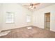 Spacious carpeted main bedroom with ceiling fan, two windows, and ensuite bath at 691 Monroe Harbor Pl, Sanford, FL 32773