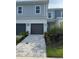 Charming home featuring a two-car garage, gray brick driveway, and well-manicured landscaping at 7810 Spectrum Dr, Kissimmee, FL 34747