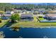 Home with screened-in pool overlooking tranquil waterfront and mature landscaping in the backyard at 8706 Irmastone Way, Orlando, FL 32817