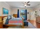 Bright bedroom featuring a ceiling fan, wood floors, and sliding glass doors leading to the pool at 8706 Irmastone Way, Orlando, FL 32817