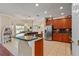 Open kitchen featuring an island with a sink, stainless steel appliances, and wood cabinets at 8706 Irmastone Way, Orlando, FL 32817
