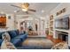 Comfortable living room featuring a ceiling fan, hardwood floors, and built-in shelves with decorative accents at 8706 Irmastone Way, Orlando, FL 32817