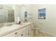 Bathroom featuring double sinks, shell-themed cabinets, and a beach-themed decor at 8878 Conway Rd, Polk City, FL 33868