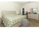 Bright bedroom with a flamingo-themed quilt, dresser with mirror, and accessible doorway at 8878 Conway Rd, Polk City, FL 33868