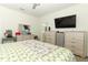 Bedroom featuring a flamingo quilt, ceiling fan, and TV, with a view into the bathroom at 8878 Conway Rd, Polk City, FL 33868