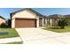 Exterior elevation of the home featuring an attached garage and manicured landscaping at 8878 Conway Rd, Polk City, FL 33868