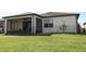 Back exterior elevation featuring a screened patio and a fenced yard at 8878 Conway Rd, Polk City, FL 33868